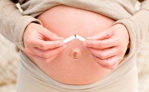 Беременная девушка ломает сигарету