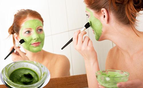 Женщина наносит кисточкой зелёный витаминный состав