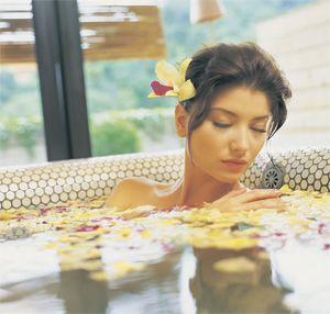 Девушка лежит в ванне с лепестками роз