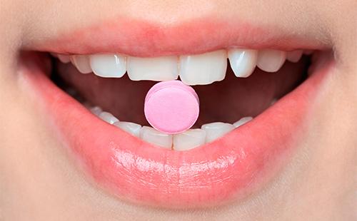 Розовая таблетка во рту